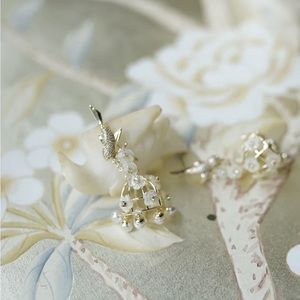 Nicola Bathie petite embellished mother of pearl birdcage Flower Earrings.